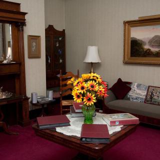 A cozy living room featuring a vintage decor style with a vibrant flower arrangement on the coffee table.