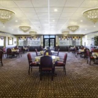 A spacious restaurant dining area with elegantly set tables and plush seating.