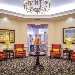 A warmly decorated lobby with comfortable seating and elegant chandelier.