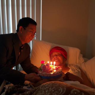 A heartfelt birthday celebration in a hospital room, with a cake and lit candles.