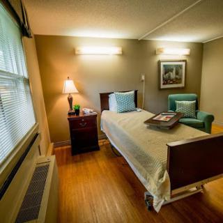 A well-lit hospital room featuring a single bed, comfortable chair, and personal touches to create a welcoming atmosphere.