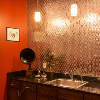A stylish kitchen area with red walls, a vintage gramophone, and modern lighting.