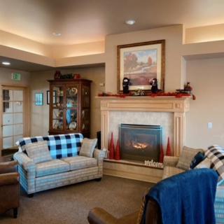A cozy living room featuring a fireplace with surrounding decor, comfortable sofas, and armchairs.