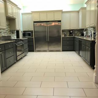 A modern, spacious kitchen with stainless steel appliances and a tiled floor.