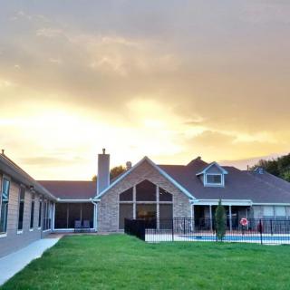 A beautiful house with a large lawn at sunset.