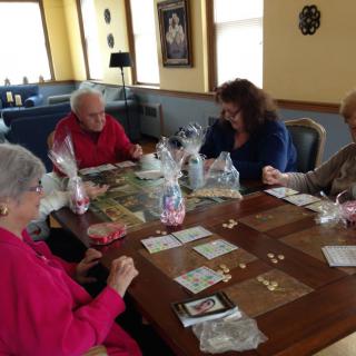 A group of seniors working on a puzzle together at a table indoors.