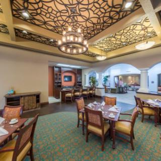 Elegant restaurant dining area with ornate ceiling design and chandelier.
