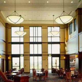 A spacious and well-lit library interior with modern design elements and large windows.