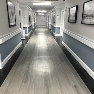 A well-lit hallway featuring a modern design with framed pictures on the walls.