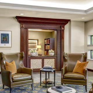 A cozy seating area in a well-decorated lobby with comfortable chairs and warm lighting.