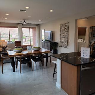 A spacious and modern dining area with an open kitchen, featuring a large table and comfortable seating.