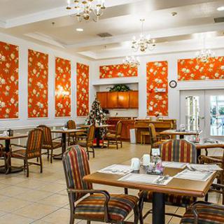 A cozy dining area with decorative orange wall panels and neatly arranged tables and chairs.