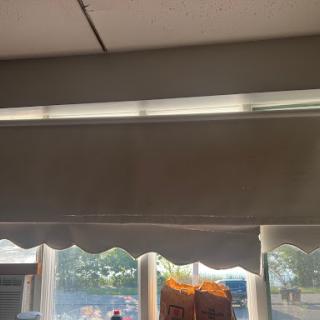 A view of window curtains with overhead lighting in a store setting.
