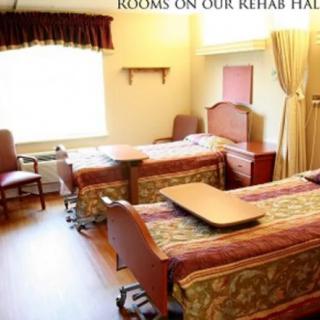A shared rehabilitation hospital room with two beds and medical equipment.