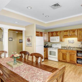 A modern kitchen and dining area featuring wooden cabinets and a table set for four.