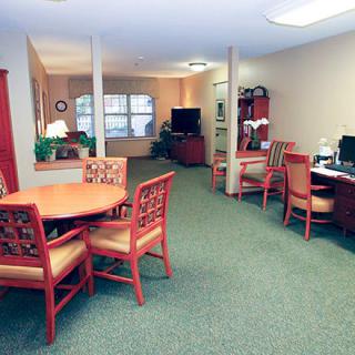 A well-furnished office space with tables, chairs, and a computer area.