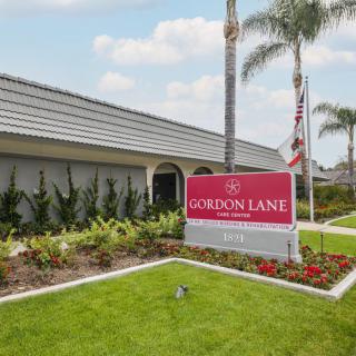 Exterior view of the Gordon Lane nursing home with a prominent sign and well-maintained landscaping.
