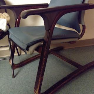 A stylish wooden chair with a blue upholstered seat, designed for comfort and aesthetics.