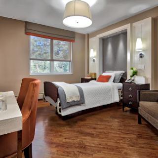 A stylish modern bedroom featuring a comfortable bed, warm lighting, and elegant furniture.