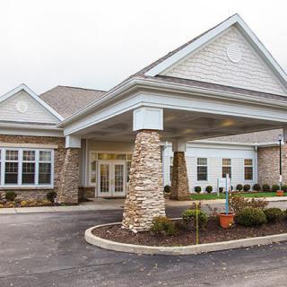 Front view of a building with stone pillars and a covered entrance.