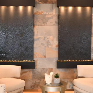 A modern interior with twin water features, cozy chairs, and decorative elements.