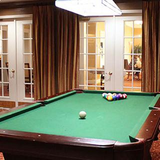 A billiard table set up in a cozy indoor recreation room.