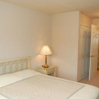 A cozy bedroom with a bed and a bedside lamp in a minimalist style.