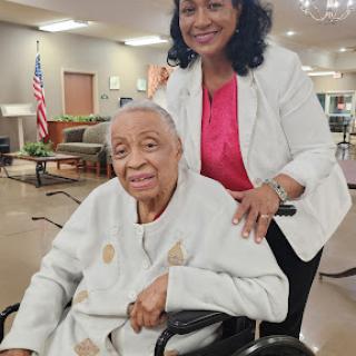 A warm moment between a caregiver and an elderly woman, showcasing support and companionship.