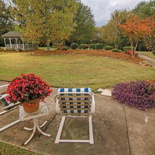 A peaceful garden view with patio furniture and lush landscaping.