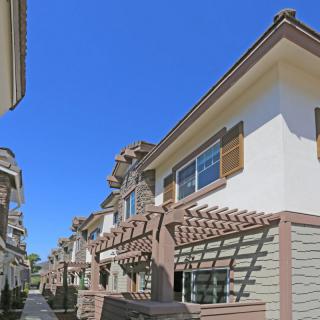 A row of townhouses under a clear blue sky.