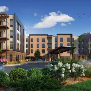A modern apartment complex surrounded by landscaped gardens on a clear day.