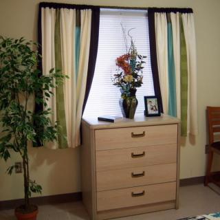 A cozy room corner with a dresser and decorative elements.