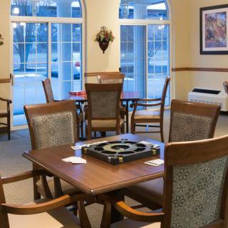 A cozy dining area with a wooden table and chairs, situated near large windows.
