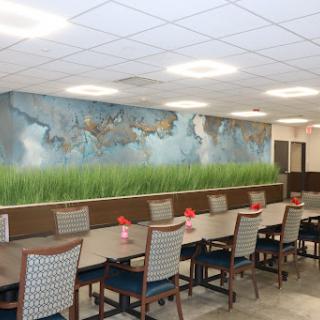 A spacious dining area featuring a beautifully designed mural and elegant table settings.