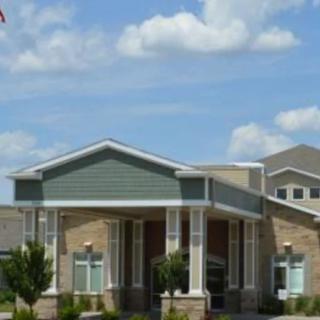 A modern residential building with a clear blue sky and scattered clouds.