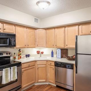 A modern kitchen with stainless steel appliances and wooden cabinets.