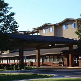 A hospital building with a modern architectural design under a clear sky.