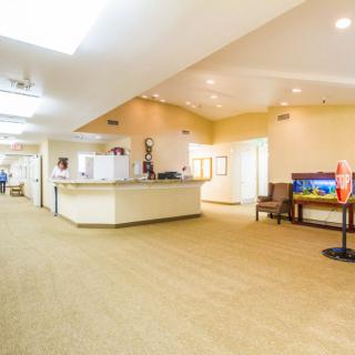 A spacious and well-lit hotel lobby with a reception desk and seating area.
