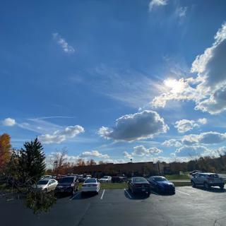 A bright autumn day with scattered clouds over a parking lot.