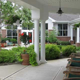 A serene view of a porch leading to a lush garden area.