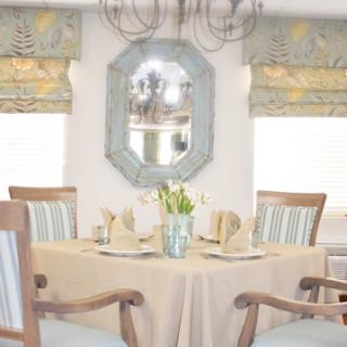 A beautifully set dining room featuring elegant decor and a charming floral centerpiece.