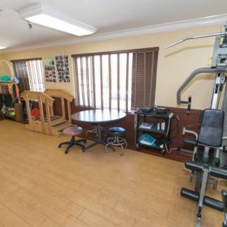 A small indoor gym featuring various exercise equipment and a play area.