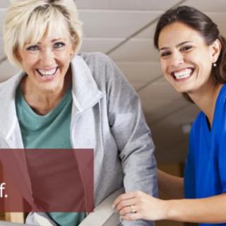A nurse assisting a smiling patient.