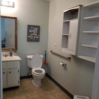 A well-organized bathroom with a toilet, sink, mirror, and storage cabinet.