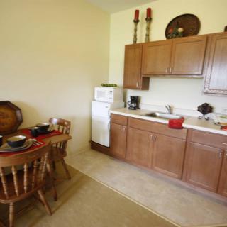 A cozy kitchen with wooden cabinets and a dining table set for breakfast.