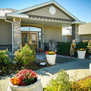 A beautifully landscaped building entrance featuring colorful flower arrangements.