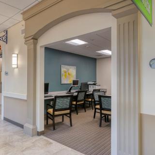 A modern office area with multiple workstations and computers, featuring an archway and decorative lighting.