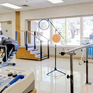A therapy room equipped with various rehabilitation and exercise equipment.
