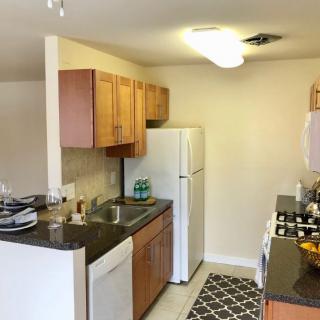A cozy kitchen featuring wooden cabinets, a refrigerator, and a gas stove.
