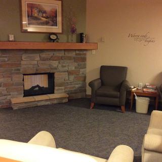 A cozy living room with a stone fireplace and comfortable armchairs.